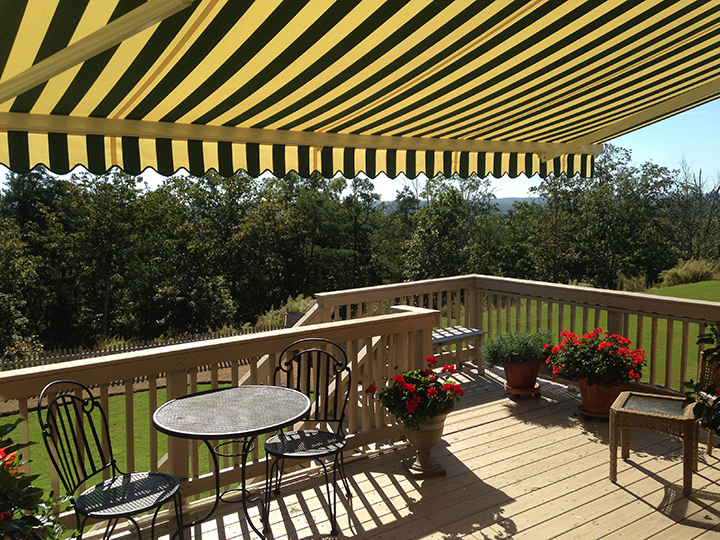 black and yellow striped awning open over a deck